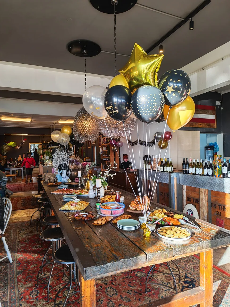 A function table dressed with black and gold balloons at On The Go.