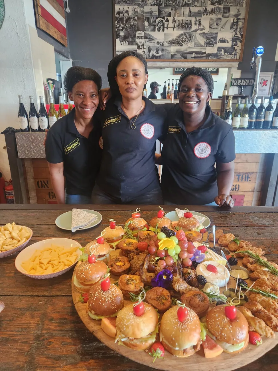 The On The Go team behind a grazing platter of sliders, wings and cheese.