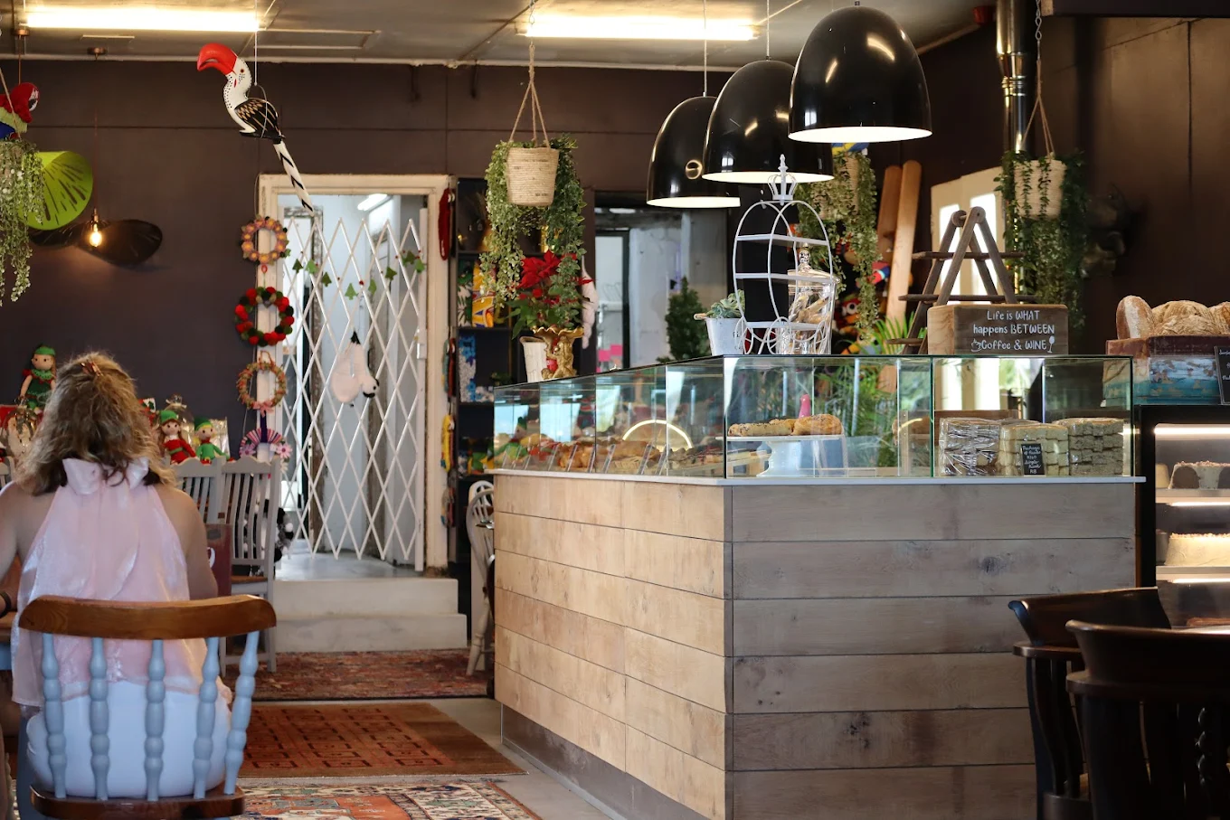 The cosy interior of On The Go with hanging plants and warm light.